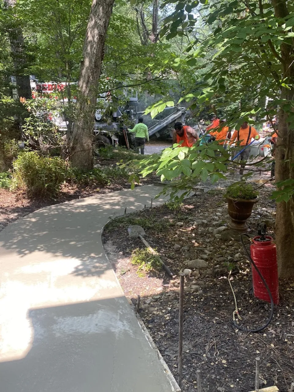 Decorative stamped concrete walkway curving through landscaping in South Jersey